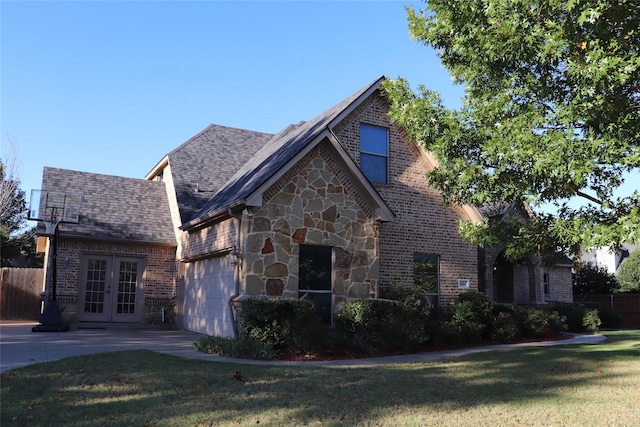 1104 Lynnwood Dr, Cleburne, TX 76033 - view of front of home with french doors, a garage, brick siding, and stone siding