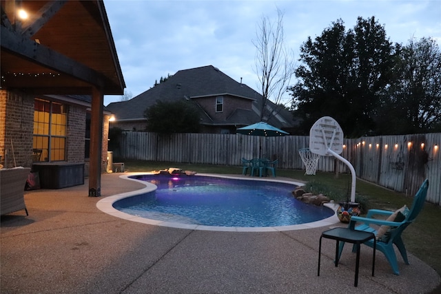 pool at dusk featuring a patio area