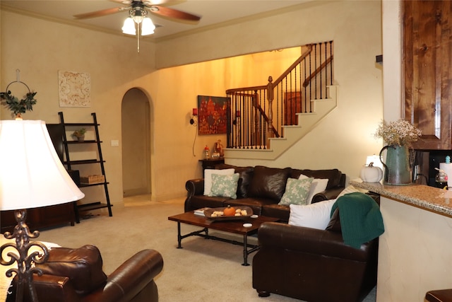 living room featuring ceiling fan, light colored carpet, and ornamental molding