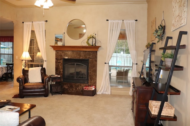 sitting room with ceiling fan, crown molding, carpet floors, and a fireplace