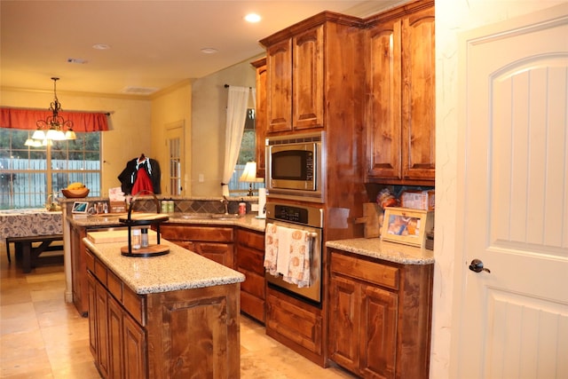 kitchen with decorative light fixtures, light stone countertops, tasteful backsplash, a notable chandelier, and stainless steel appliances