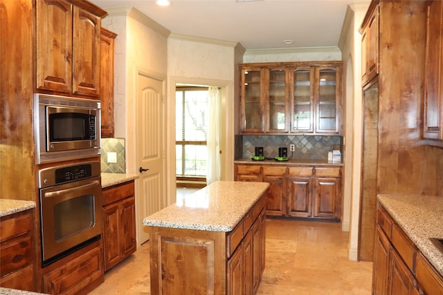 1104 Lynnwood Dr, Cleburne, TX 76033 - kitchen featuring stainless steel appliances, ornamental molding, backsplash, glass insert cabinets, and brown cabinets