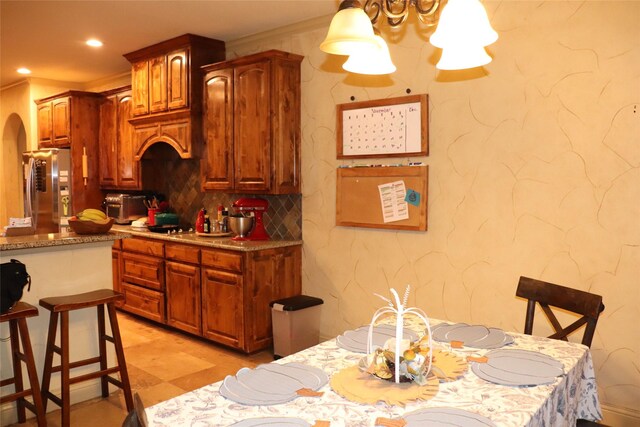 1104 Lynnwood Dr, Cleburne, TX 76033 - kitchen featuring freestanding refrigerator, arched walkways, decorative backsplash, recessed lighting, and brown cabinetry