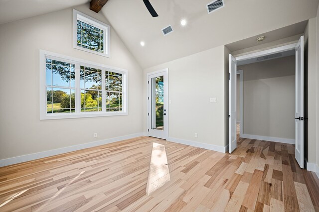 unfurnished bedroom featuring multiple windows, access to exterior, light hardwood / wood-style floors, and high vaulted ceiling