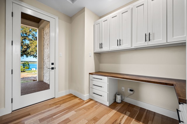 unfurnished office with light wood-type flooring and built in desk