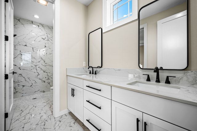 bathroom with a tile shower, vanity, and toilet