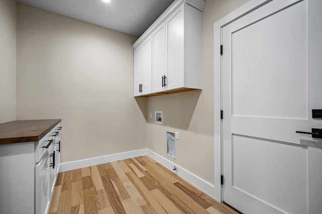 washroom featuring cabinets, hookup for a washing machine, and light hardwood / wood-style floors