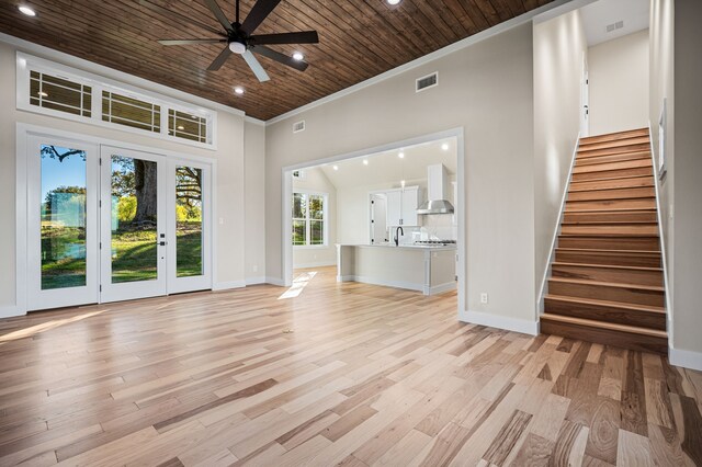 unfurnished living room with sink, crown molding, wooden ceiling, ceiling fan, and light hardwood / wood-style floors