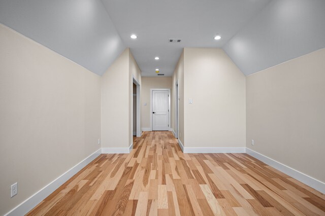 corridor featuring light hardwood / wood-style flooring and lofted ceiling