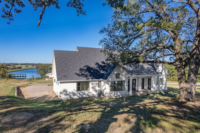 view of front of property with a front yard and a water view