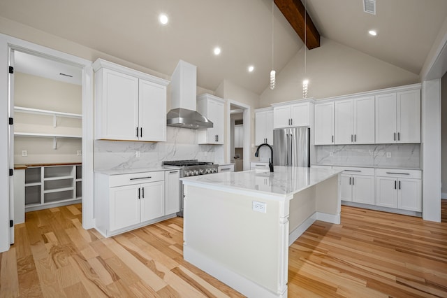 kitchen featuring decorative backsplash, appliances with stainless steel finishes, light hardwood / wood-style floors, and white cabinets