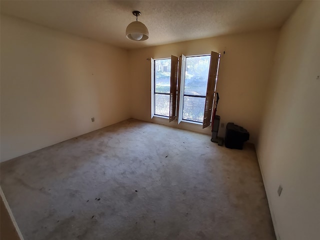 carpeted empty room with a textured ceiling