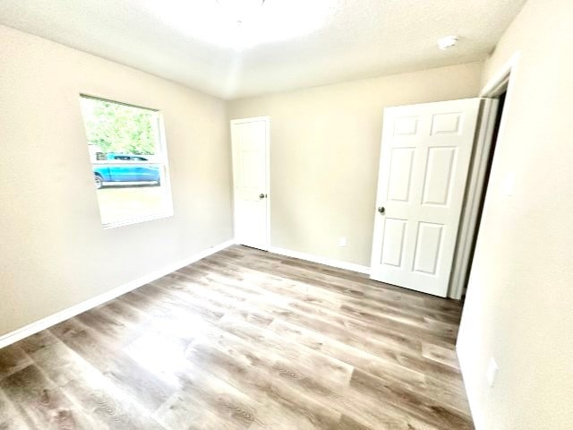 unfurnished room with hardwood / wood-style flooring