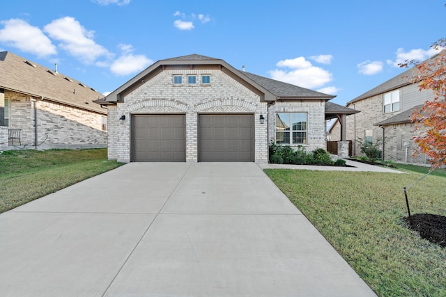 french country style house featuring an attached garage, brick siding, a shingled roof, driveway, and a front yard