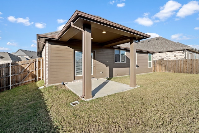 rear view of property featuring a yard and a patio