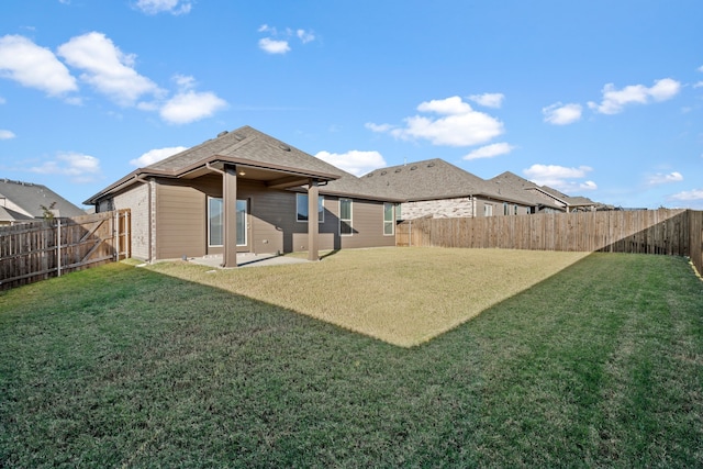 rear view of property featuring a yard and a patio