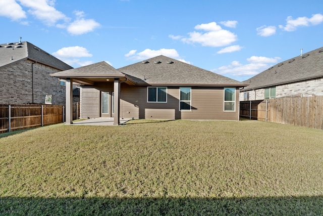 rear view of property with a yard and a patio area