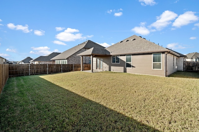 rear view of house featuring a lawn