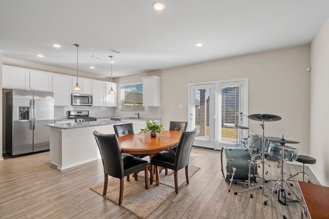 dining area with sink and light hardwood / wood-style flooring