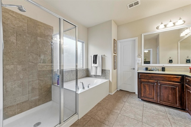 bathroom with tile patterned floors, vanity, and shower with separate bathtub