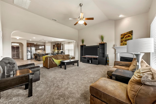 carpeted living room featuring ceiling fan and lofted ceiling