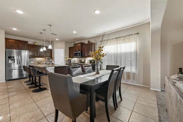 dining space with light tile patterned floors and sink