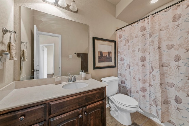 bathroom featuring tile patterned floors, vanity, and toilet