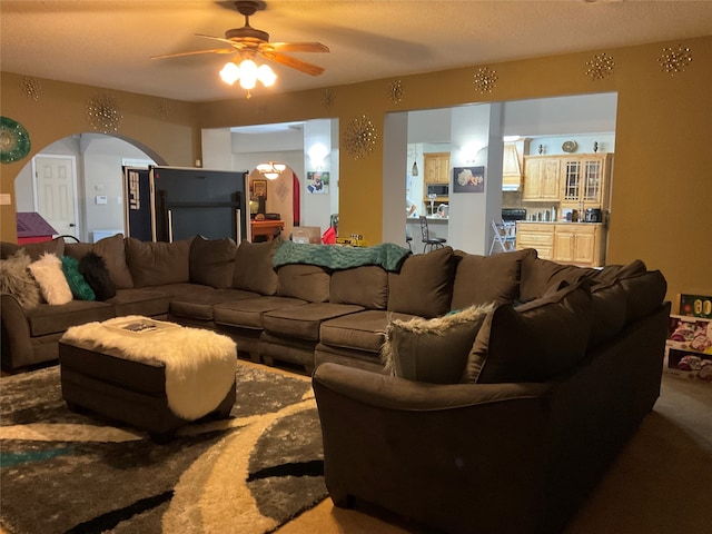 living room with ceiling fan, carpet, and a textured ceiling