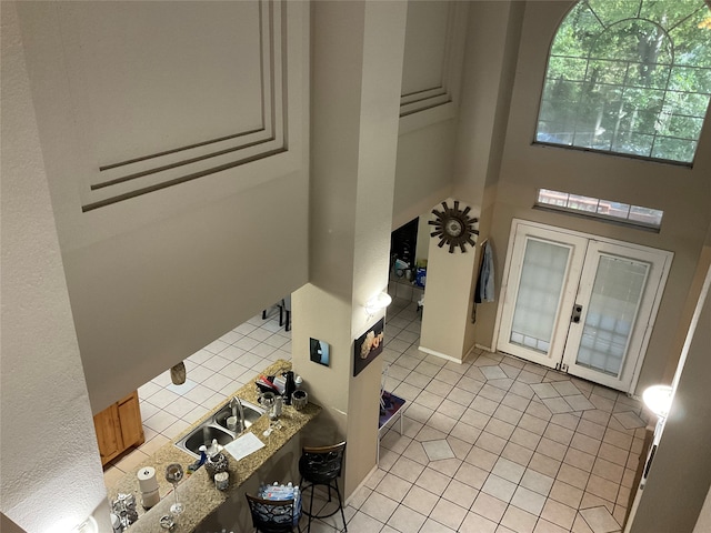 foyer entrance featuring light tile patterned floors, french doors, and sink