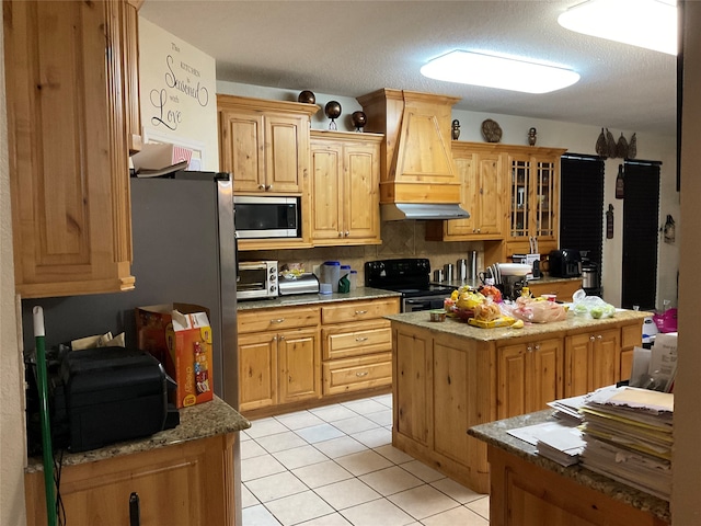 kitchen featuring backsplash, custom range hood, black range with electric cooktop, a kitchen island, and light tile patterned flooring