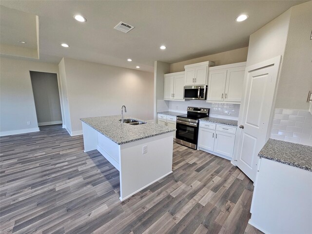 kitchen featuring backsplash, stainless steel appliances, sink, white cabinets, and an island with sink