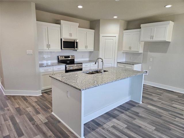 kitchen with white cabinets, stainless steel appliances, and a center island with sink