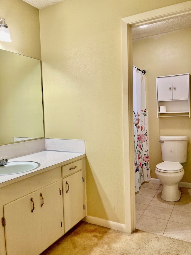 bathroom featuring tile patterned flooring, vanity, a textured ceiling, and toilet