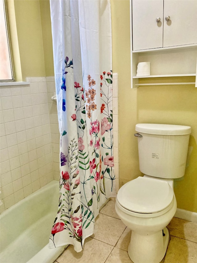 bathroom with tile patterned floors, shower / bath combination with curtain, and toilet