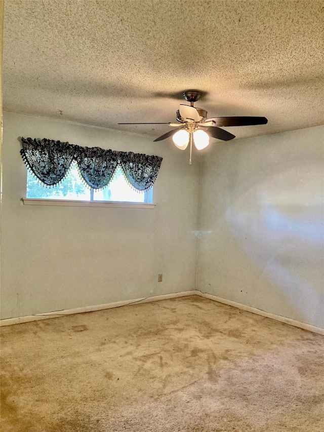 empty room with ceiling fan, carpet, and a textured ceiling