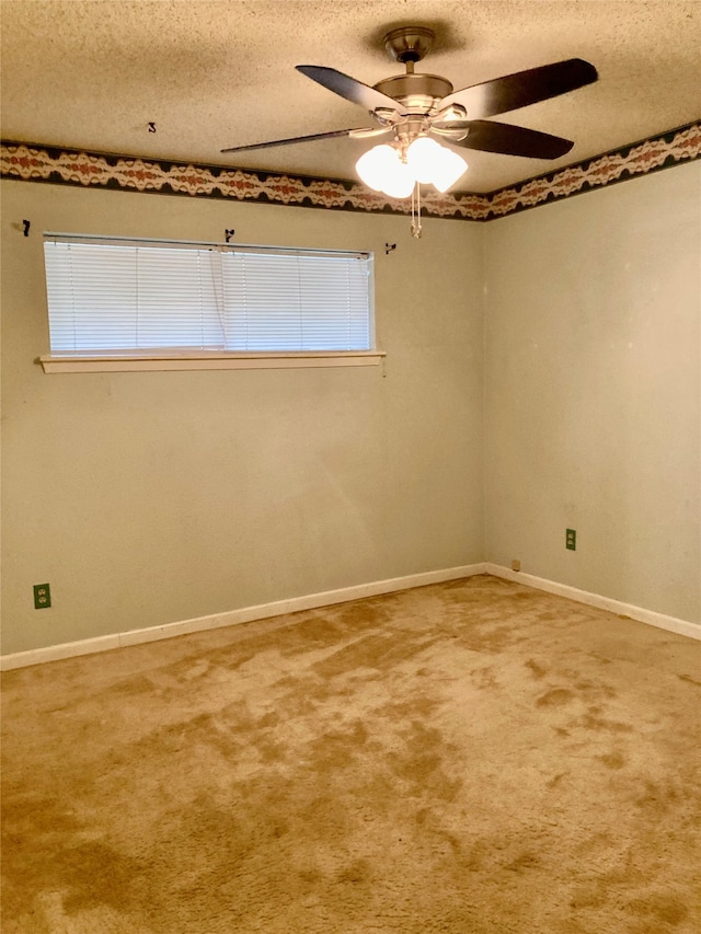 spare room featuring carpet, ceiling fan, a textured ceiling, and a wealth of natural light