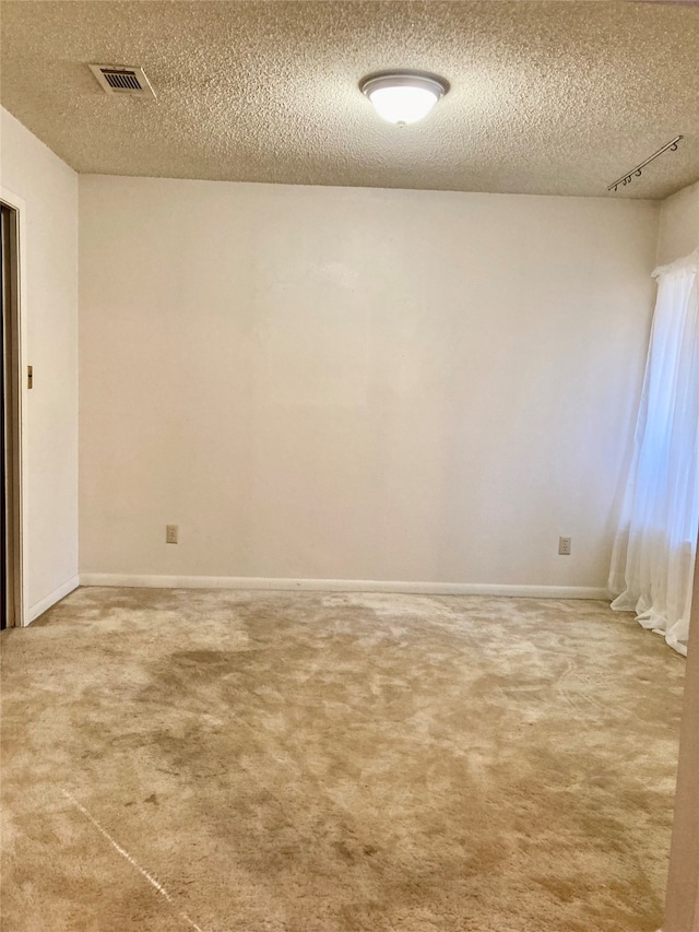 unfurnished room featuring carpet flooring and a textured ceiling