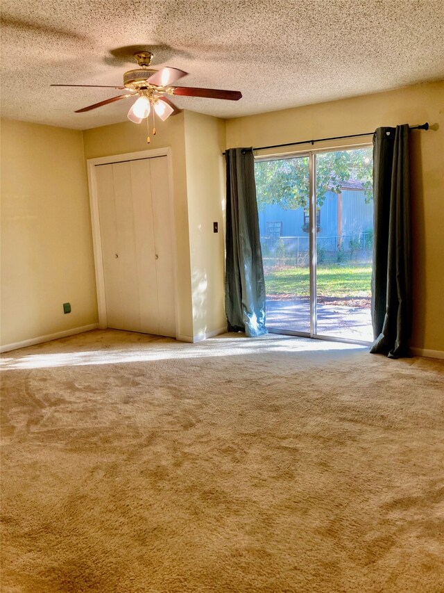 unfurnished bedroom with carpet flooring, ceiling fan, a textured ceiling, and access to outside