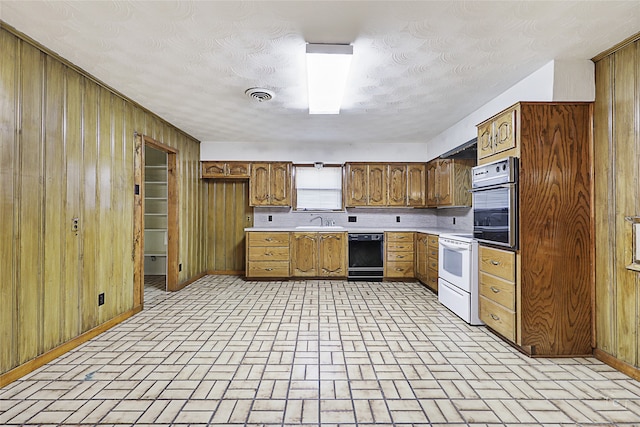 kitchen with white electric range, sink, wood walls, and stainless steel oven