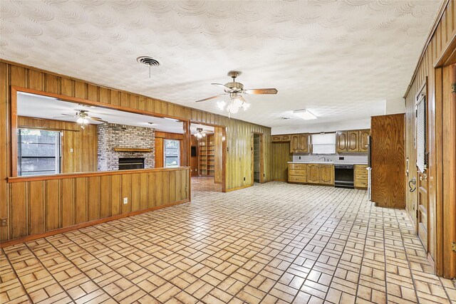 kitchen with white electric range, sink, wood walls, and stainless steel oven