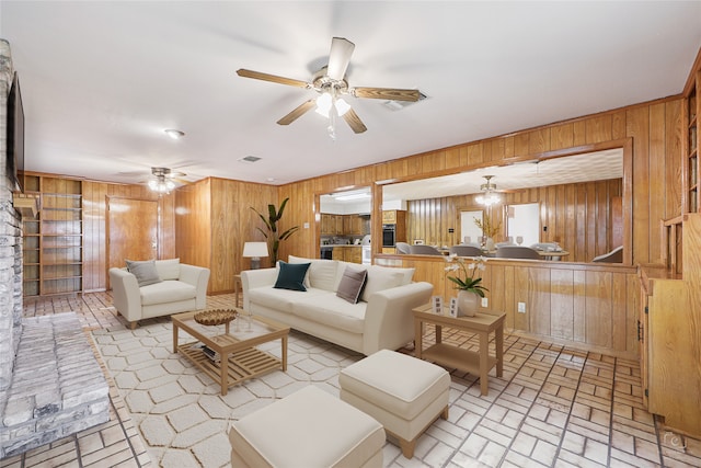 living room featuring ceiling fan and wooden walls