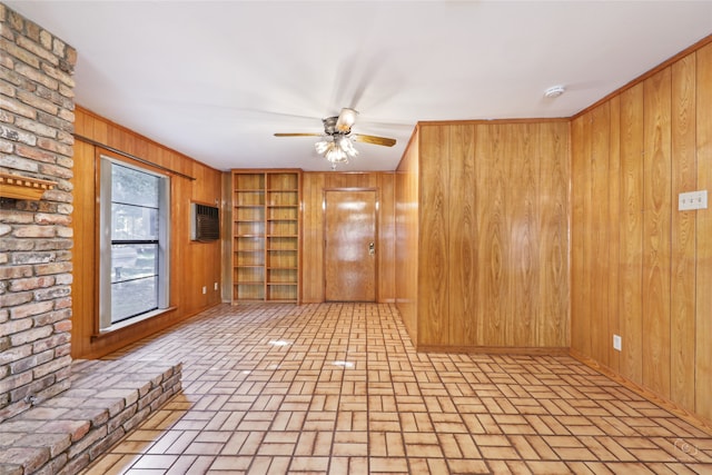 unfurnished living room featuring built in features, ceiling fan, and wooden walls