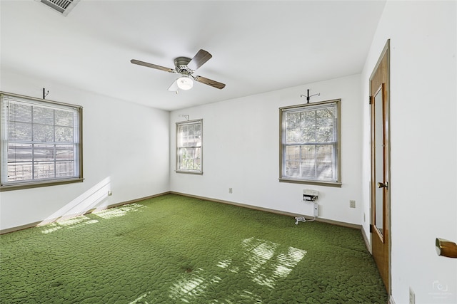 carpeted spare room with a wealth of natural light and ceiling fan