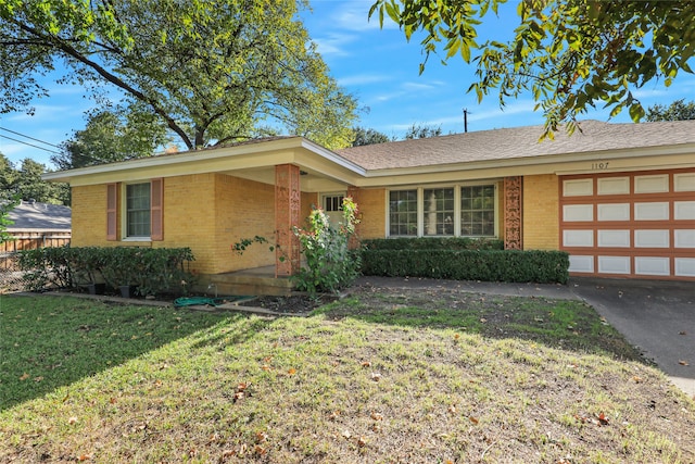 single story home with a garage and a front lawn