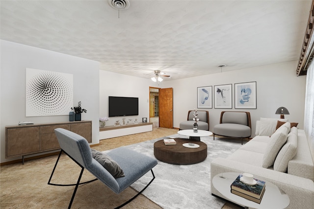 living room with light carpet, a textured ceiling, and ceiling fan