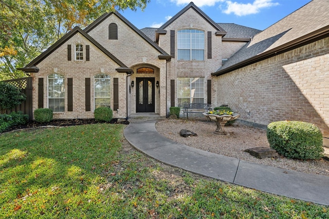 french provincial home featuring a front lawn and french doors