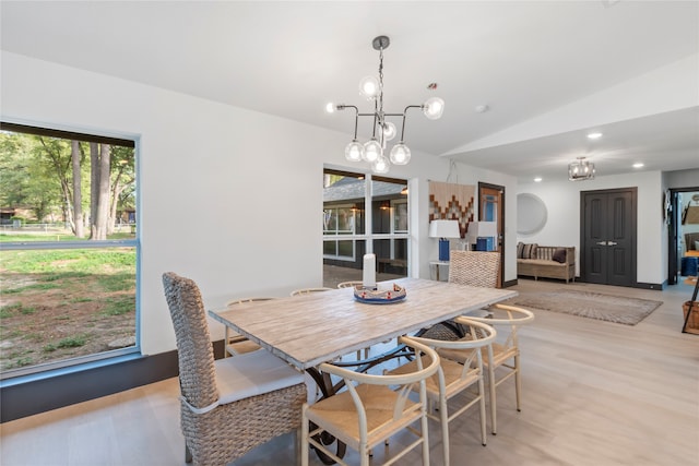 dining space featuring a chandelier, light hardwood / wood-style floors, and vaulted ceiling