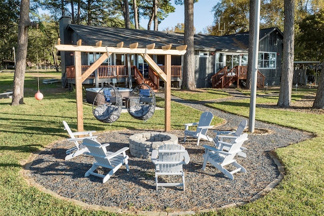 exterior space with a pergola, a wooden deck, and an outdoor fire pit