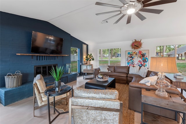 living room featuring a fireplace, light hardwood / wood-style floors, vaulted ceiling, and plenty of natural light