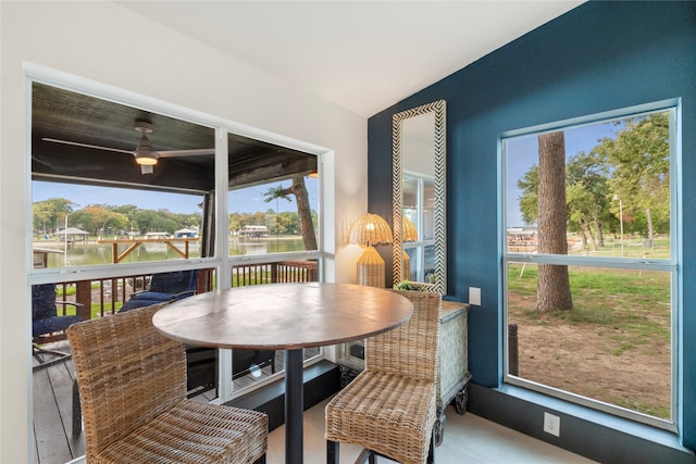 sunroom featuring a water view, vaulted ceiling, and a healthy amount of sunlight